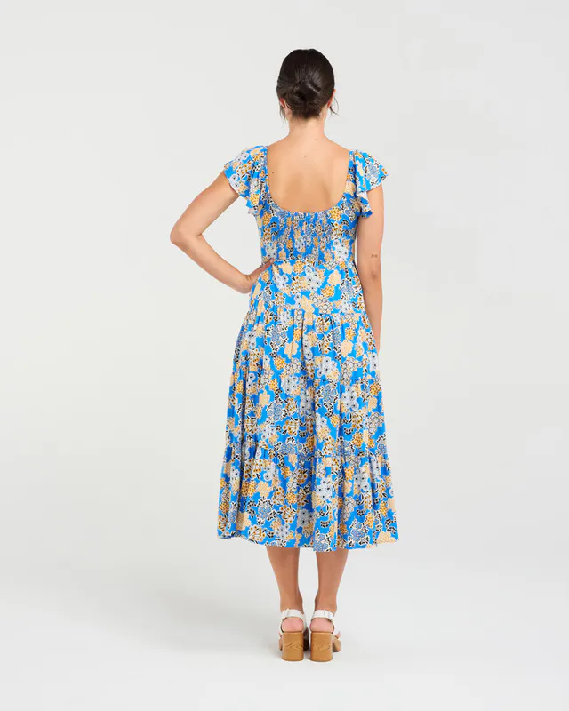 Model wearing Blue Bouquet Brielle Flutter Sleeve Dress By Blackstone Available at Beetees Nelson