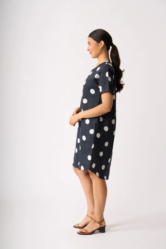 Model wearing True Navy Spot Back Pleat Dress By Foil Available at Beetees Nelson
