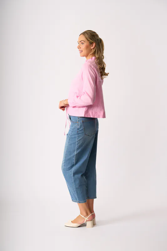 Model wearing Pink Ruffle Neck Jacket By Foil Available at Beetees Nelson