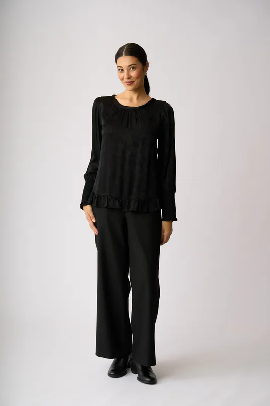 Model wearing Black Shirred Cuff Scoop Hem Top By Oh Three Available at Beetees Nelson