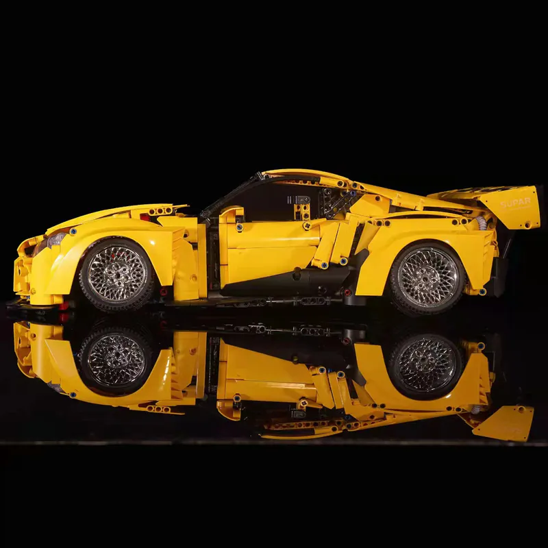 The yellow sports car is a sleek and vibrant model constructed entirely out of building blocks. It comes equipped with a battery-powered engine and advanced remote control features