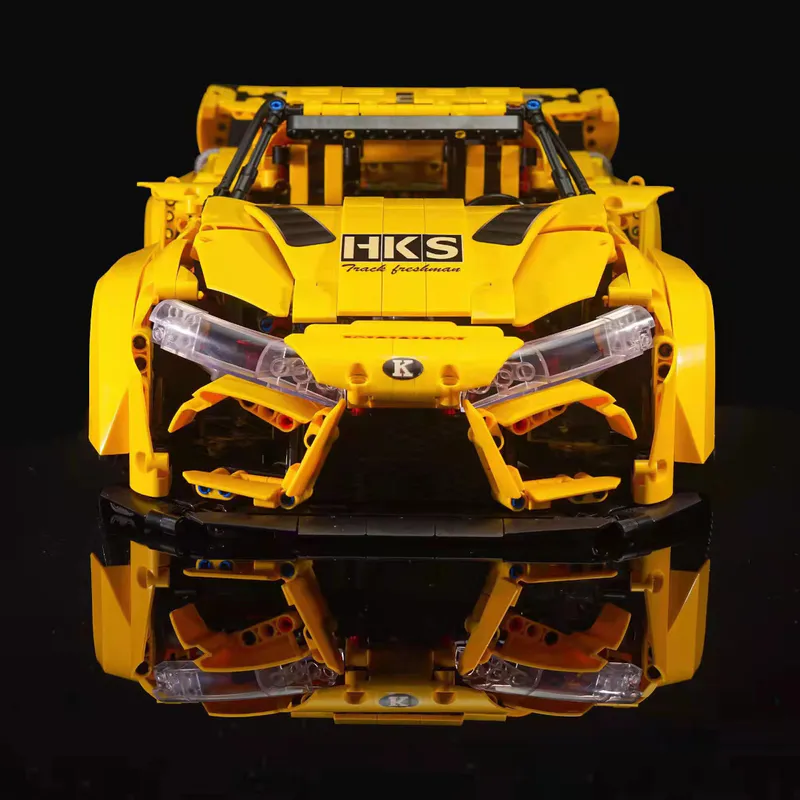 The yellow sports car is a sleek and vibrant model constructed entirely out of building blocks. It comes equipped with a battery-powered engine and advanced remote control features