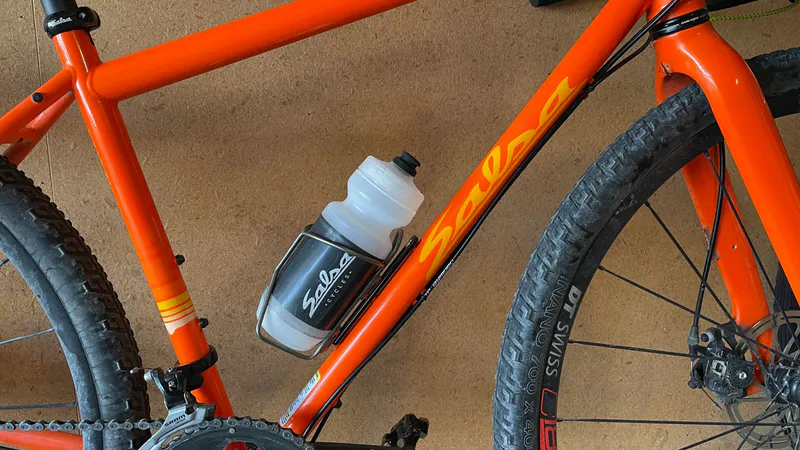 Bicycle water bottle cage adaptor shown installed, bottle cage repositioned 52mm down.