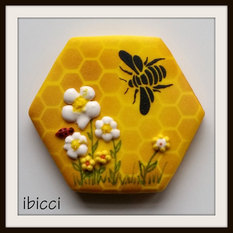Single stencilled bee on honeycomb background with flowers and ladybird