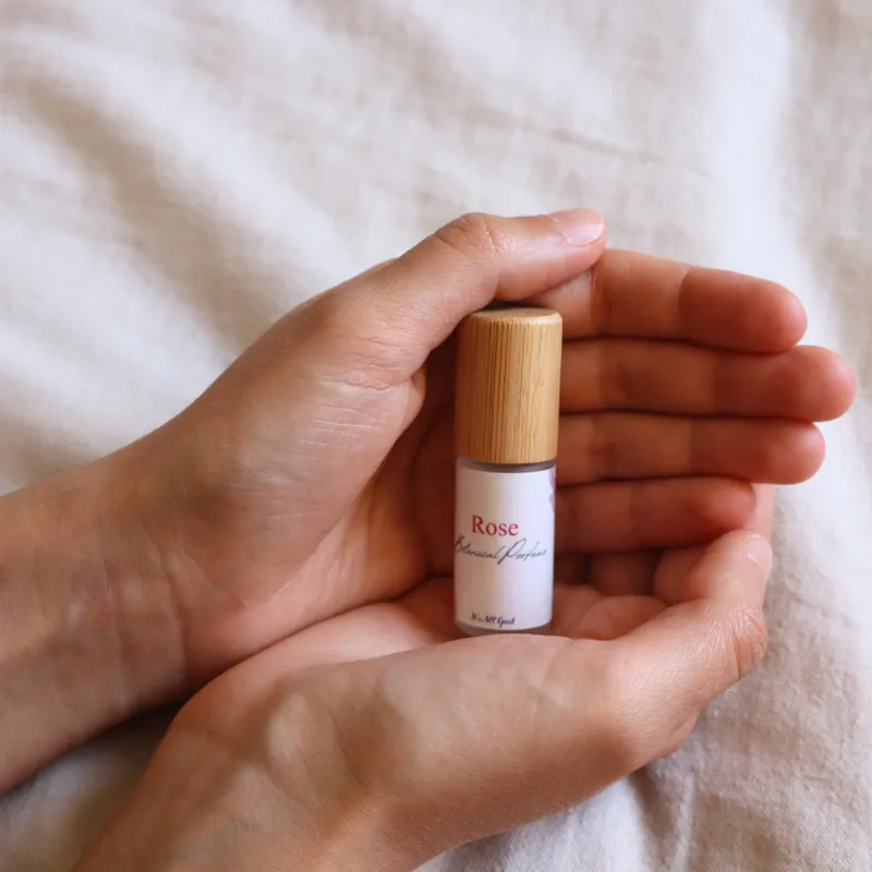 A person holding a bottle of Rose botanical perfume