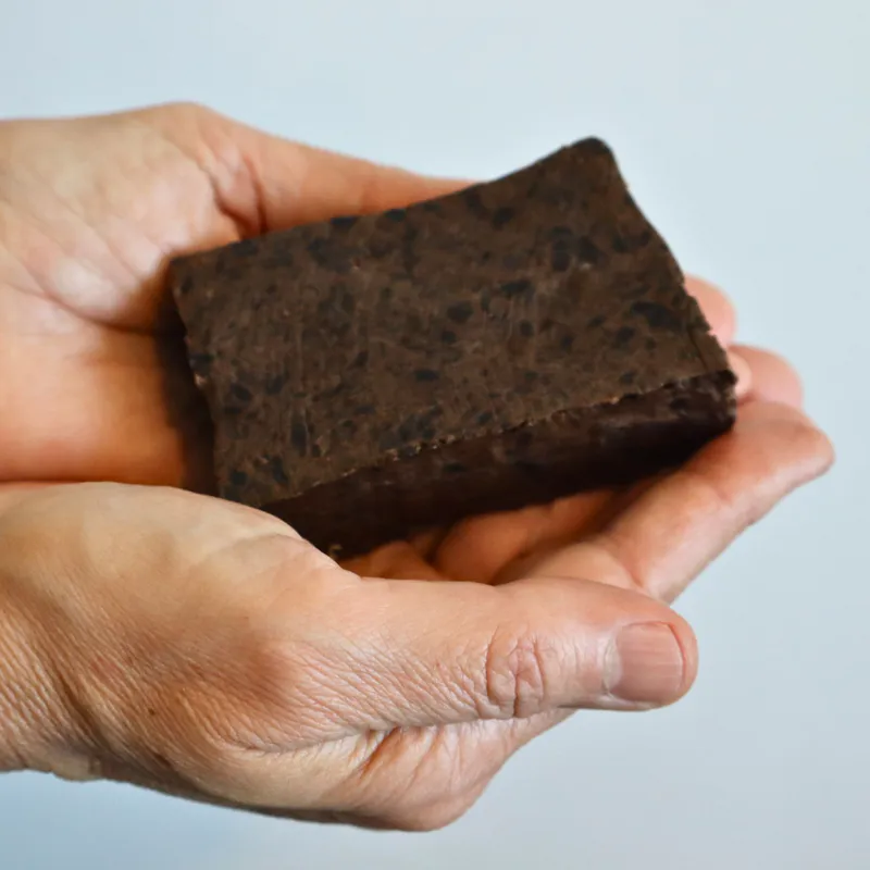 hands holding pine tar tallow dead sea mud soap bar