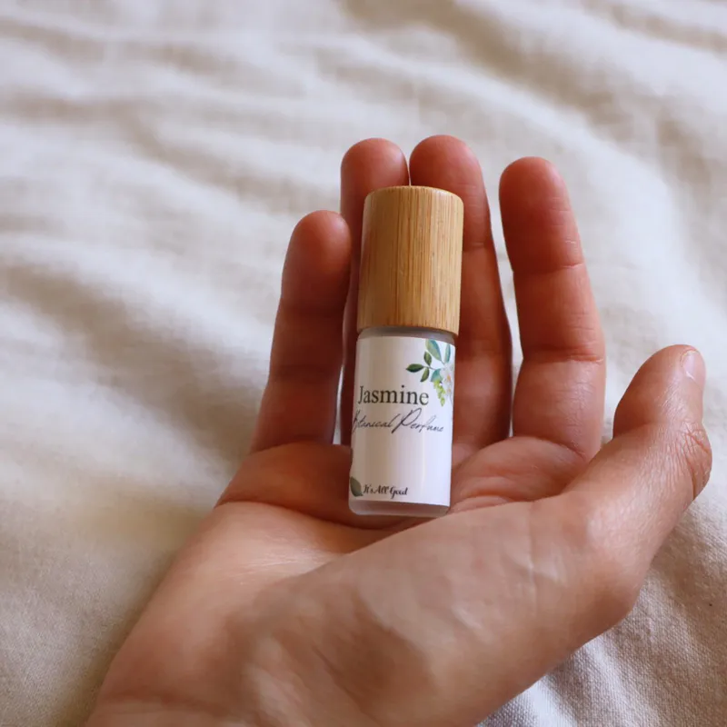 A person holding a bottle of Jasmine botanical perfume