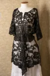 A black lace over-jacket displayed on a dress form