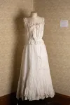 A white corset cover and long white petticoat displayed on a dressform