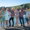 Six happy people dressed in Mr Peacock menswear patterned long sleeve and shirtsleeve shirts and colourful Emma Manhart dresses by the Akaroa Wharf