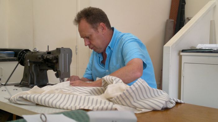 Nigel Neiman at work sewing fabric for a clients bed head
