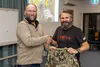 President Greg Couper presenting Sitka T-Shirt giveaway to Greg Monahan