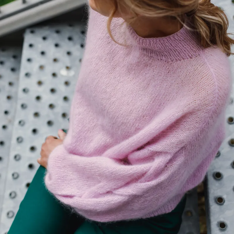 A soft cable on the sleeve of a pink, hand knit, mohair sweater that was hand knit. The pattern is available for purchase.