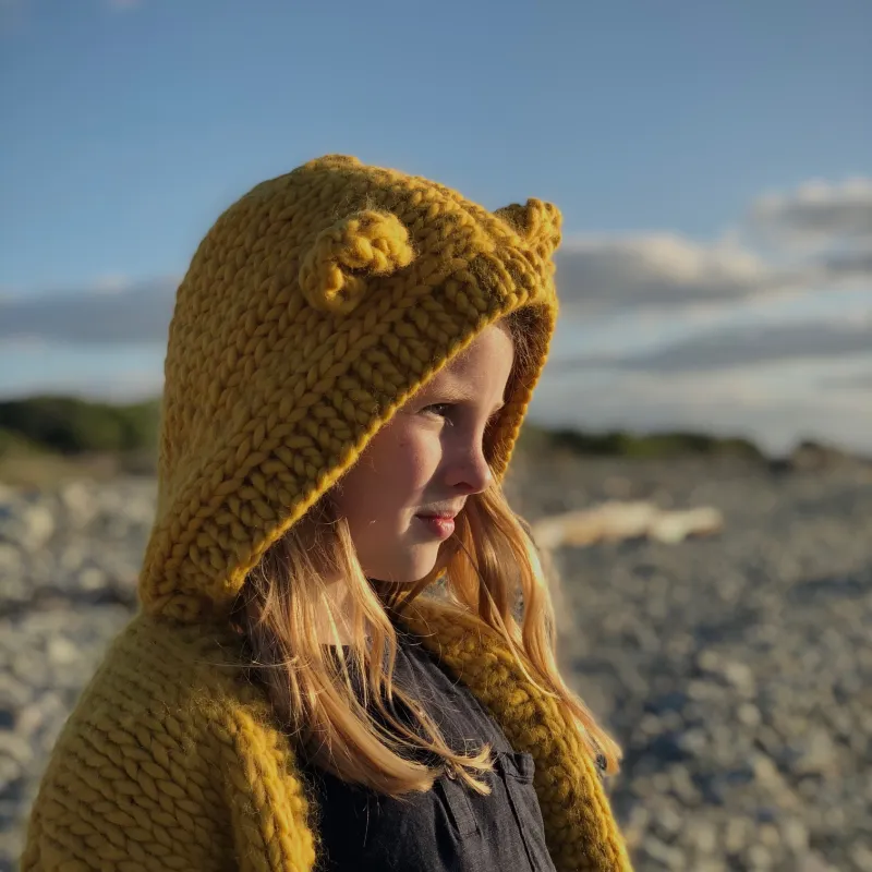 Child wearing a chunky cardigan with hood and ears