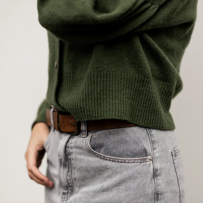 Close up of the hem on the Gather Sleeve Cardi knitting pattern. The background is a plain white wall.