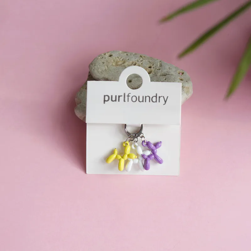 Purple, yellow and white knit stitch markers in the shape of balloon animals