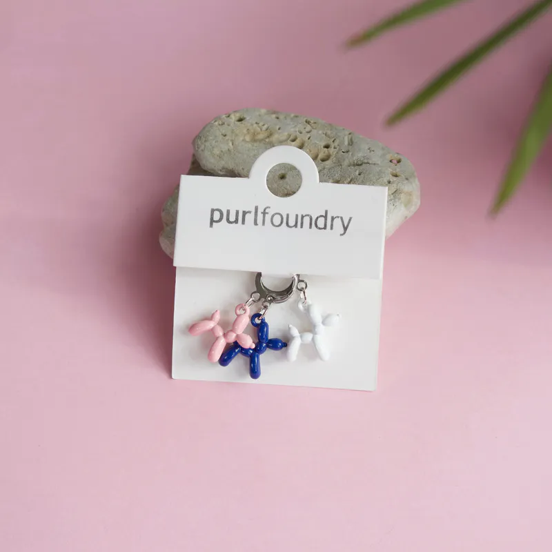 Navy, pink and white knit stitch markers in the shape of balloon animals