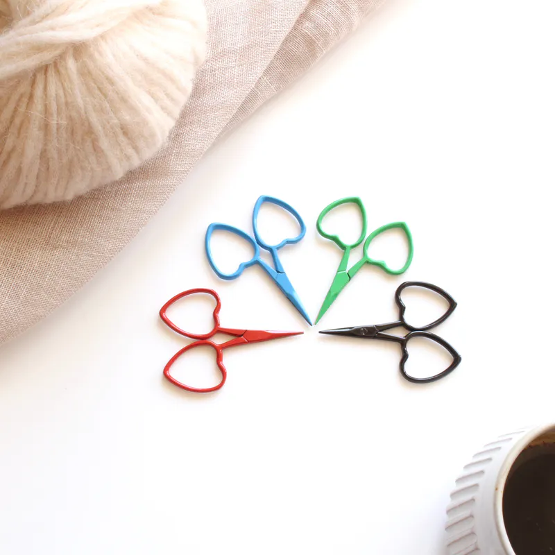 Four scissors with heart shaped handles. They are in four different colours