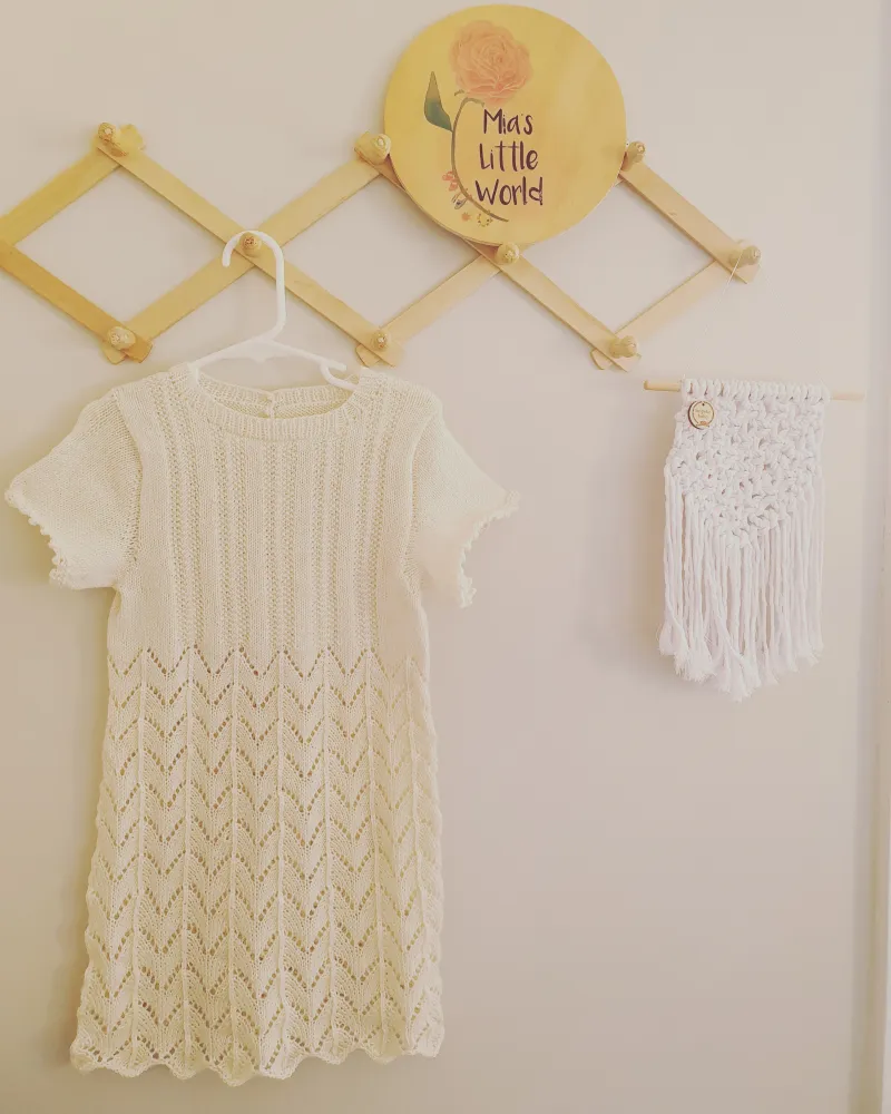 Pelongpelong dress hanging on wooden pegs