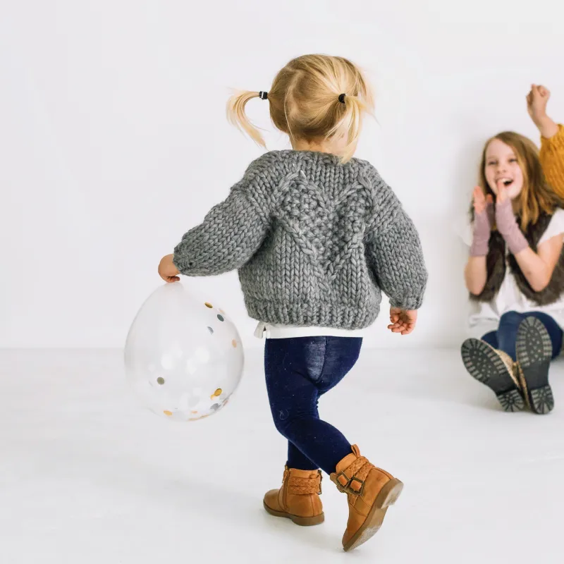 Hand knit cardigan for children with a heart motif on the back