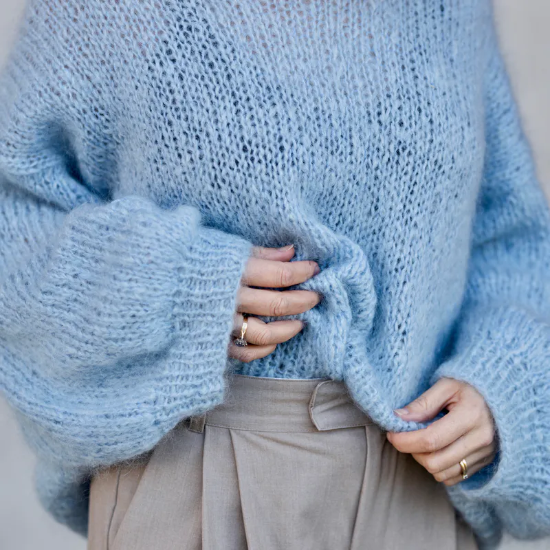 A blue handknit, 12ply mohair sweater in a very loose gauge.