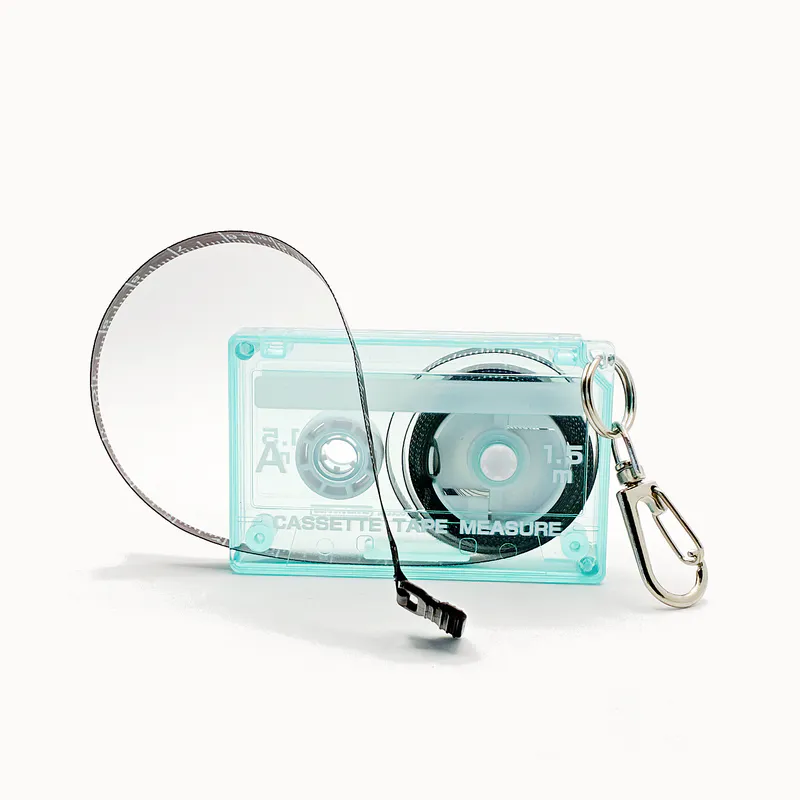 A tape measure in the shape of an 80s cassette tape in a transparent turquoise blue.