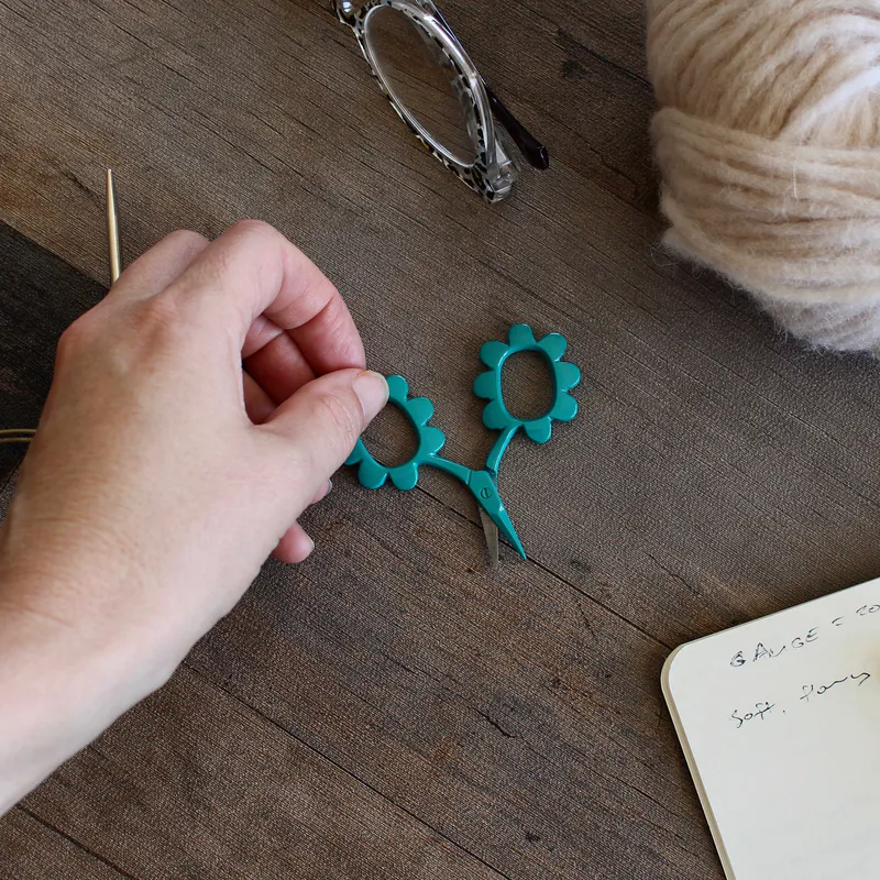 Teal coloured scissors with handles in the shape of daisys