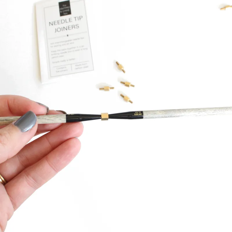 A double ended screw in the middle of two Lykke interchangeable knitting needle tips