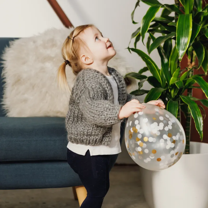 Child wearing a warm hand knit cardigan in thick yarn