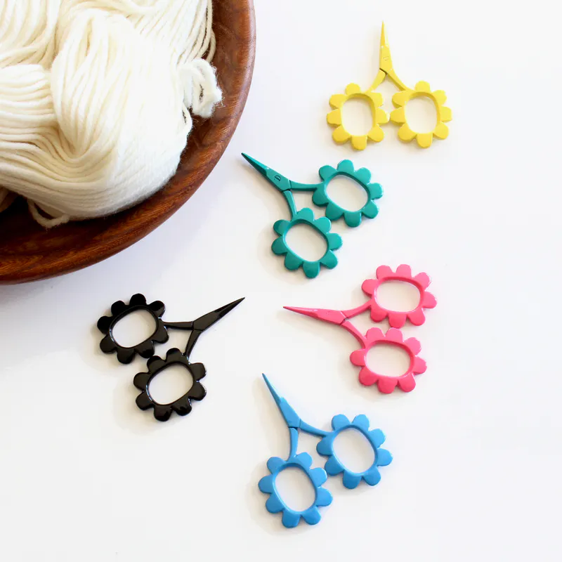 A group of flower shaped scissors in 5 different colours