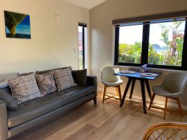 This peaceful stylish suite is set above and behind lush sub tropical gardens and enjoys a sunny north facing deck with partial sea views looking out towards Tauranga Bay. 
