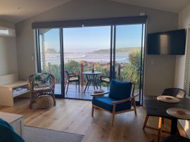 Perched immediately above the popular surf spot with sweeping uninterrupted views of Tauranga Bay.