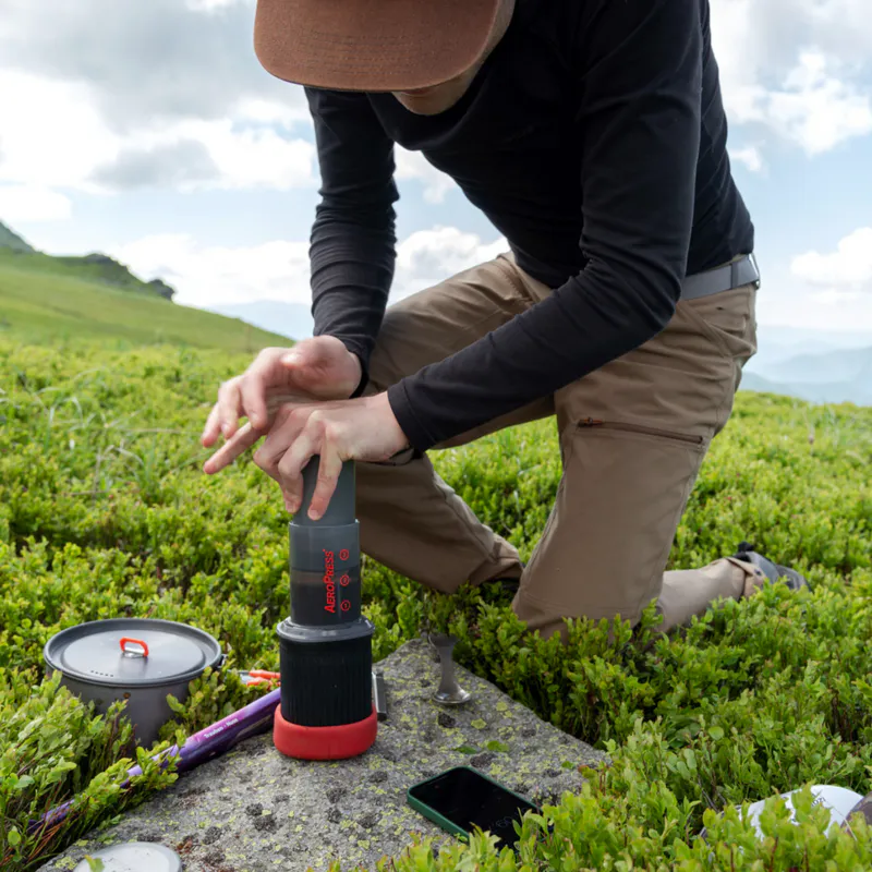 Man uses AeroPress Go on hillside