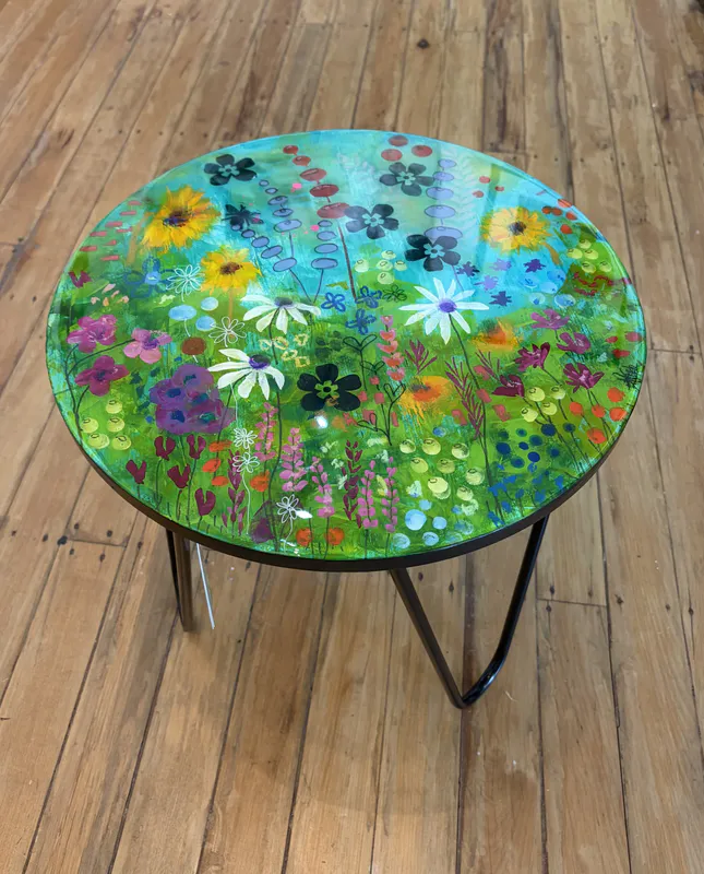 An original floral-painted side table with resin coating by Kristin Hyde, available at The Little Gallery Tairua