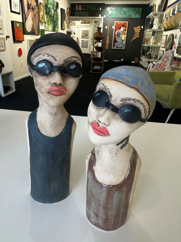 Tall Swimming Lady sculptures with swimming caps by Nikky Seales, available at The Little Gallery Whangamatā