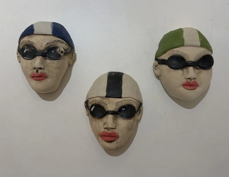 Ceramic Swimmer Heads with goggles and swimming caps by Nikky Seales, available at The Little Gallery Tairua