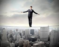 Man in suit balances on a tightrope above a cityscape